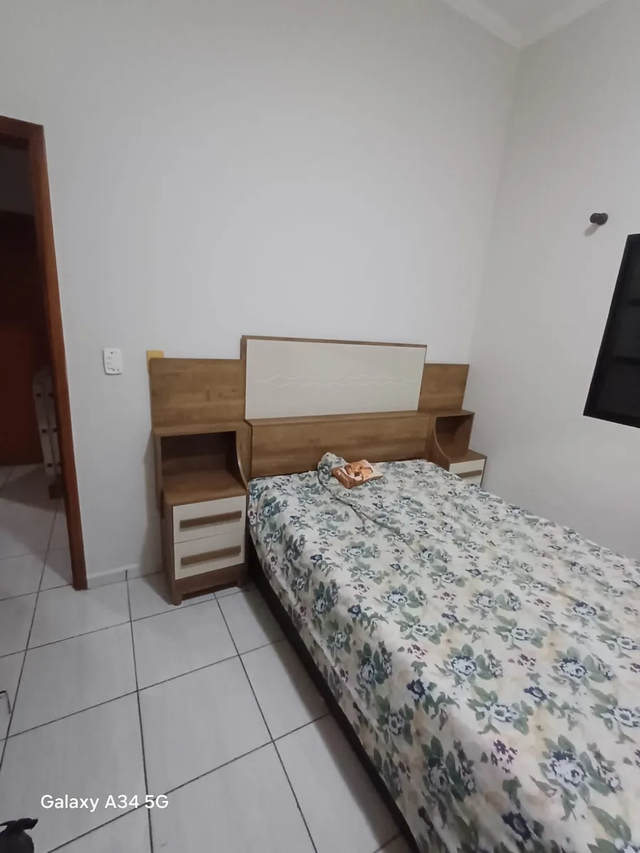 Montagem de cama de casal com cabeceira de madeira e criado-mudo