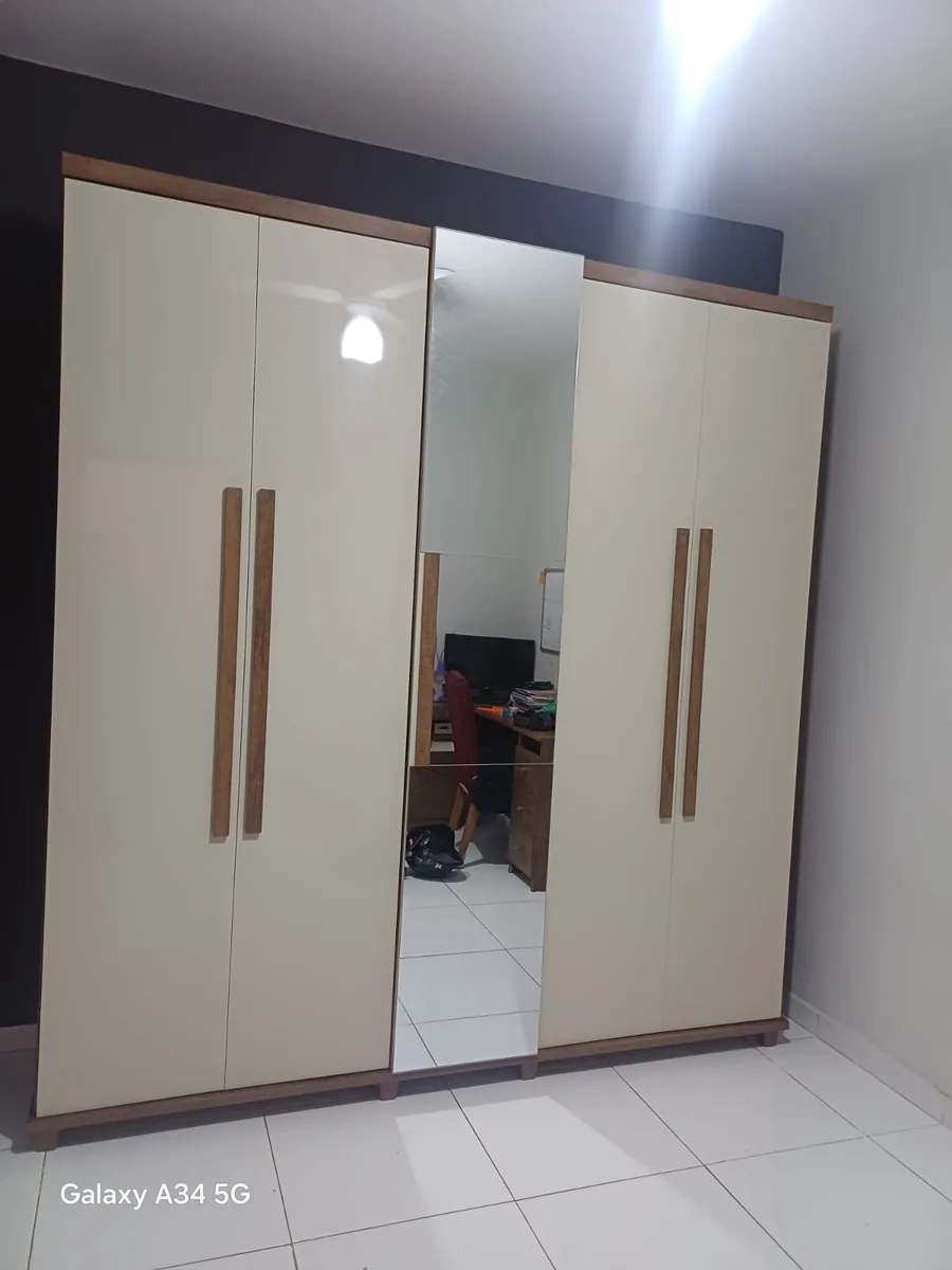 Montagem de guarda-roupa casal com portas de correr e espelho em quarto