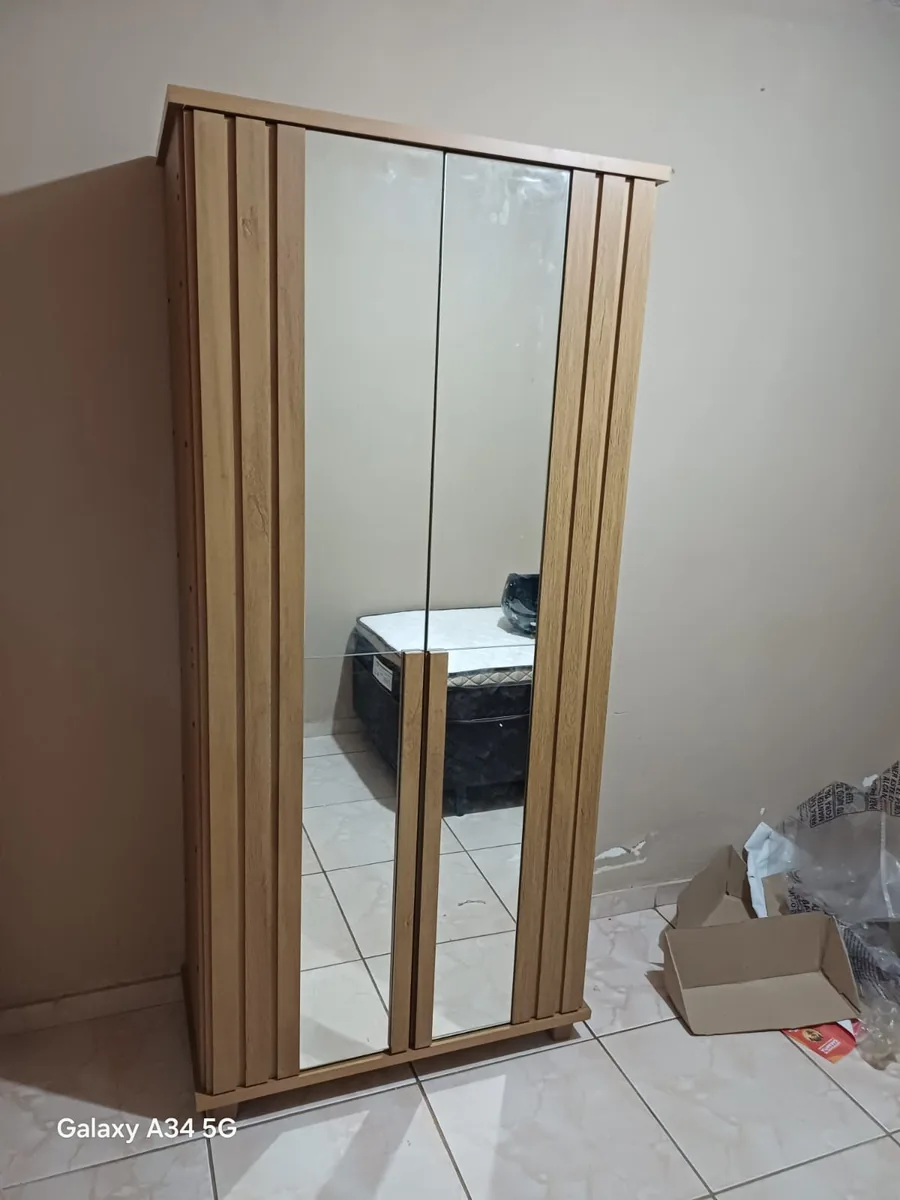 Montagem de guarda-roupa de solteiro compacto com porta espelhada